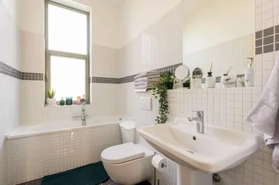 a white bathroom with a sink and a toilet at Bel appart proche de gare du Midi, à côté du Centre Ville in Brussels