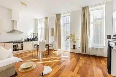 a living room with a couch and a table at Bel appart proche de gare du Midi, à côté du Centre Ville in Brussels