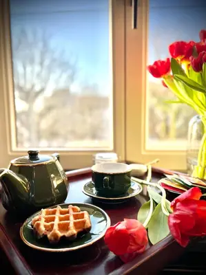 a table with a waffle on a plate and flowers at L'atique by Agelandkaai be with Free Parking in Ghent