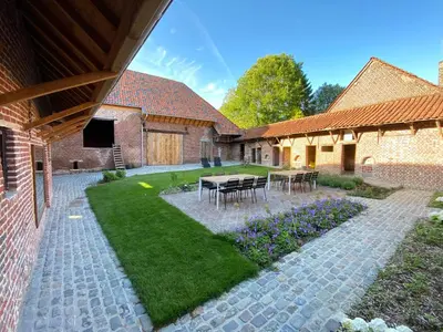 a patio with a table and chairs in a yard at Quadratum 1769 in Herzele