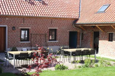 two tables and chairs in front of a brick building at Quadratum 1769 in Herzele