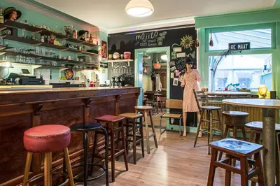 a woman standing at a bar in a restaurant at Vakantiewoning in Mol centrum met eigen bar 