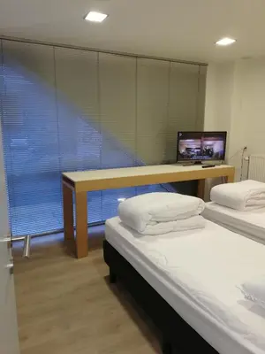 a room with two beds and a desk with a computer at NUVOLA Summer Spring in Zottegem