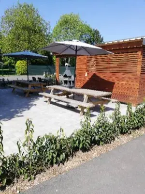 a patio with two picnic tables and an umbrella at NUVOLA VIEW in Zottegem