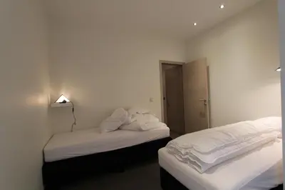 two beds in a room with white sheets and towels at NUVOLA VIEW in Zottegem
