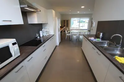a kitchen with white cabinets and a sink and a microwave at NUVOLA VIEW in Zottegem