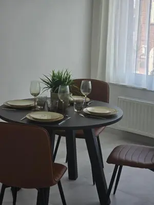 a black table with plates and wine glasses on it at Brussels North - Pajot Apartments in Wemmel