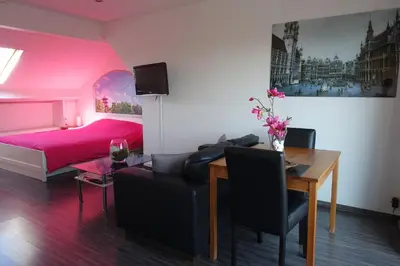 a bedroom with a bed and a table and a dining room at B&B Basilique in Brussels