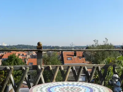a balcony with a table and a view of the city at B&B Basilique in Brussels