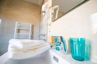 a bathroom with a sink with a mirror and towels at Smart Appart - City in Brussels