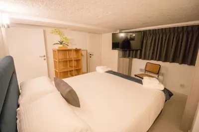a bedroom with a large white bed and a couch at Smart Appart - City in Brussels