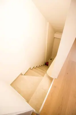 a staircase in a room with white walls and wooden floors at Smart Appart - City in Brussels