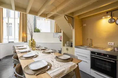 a kitchen with a long table with chairs and a sink at SHWAY60 Family House in Antwerp