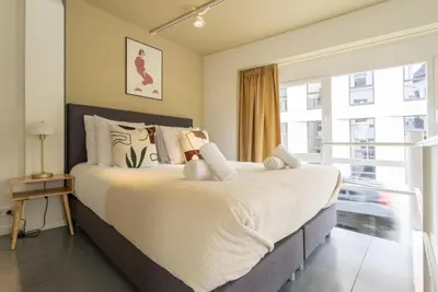 a bedroom with a large bed and a large window at SHWAY60 Family House in Antwerp