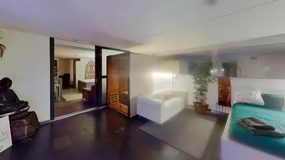 a living room with a bed and a chair in it at nice and cosy place with jacuzzi and sauna to relax in the centre of antwerp in Antwerp