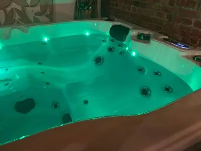 a green bath tub with lights in a bathroom at nice and cosy place with jacuzzi and sauna to relax in the centre of antwerp in Antwerp