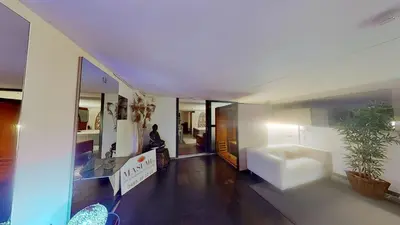 a living room with a person sitting on a couch at nice and cosy place with jacuzzi and sauna to relax in the centre of antwerp in Antwerp