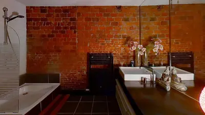 a bathroom with a sink and a brick wall at nice and cosy place with jacuzzi and sauna to relax in the centre of antwerp in Antwerp