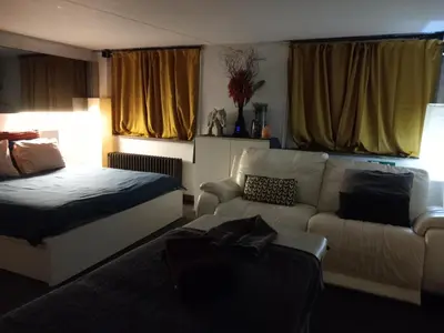 a living room with a bed and a couch at nice and cosy place with jacuzzi and sauna to relax in the centre of antwerp in Antwerp