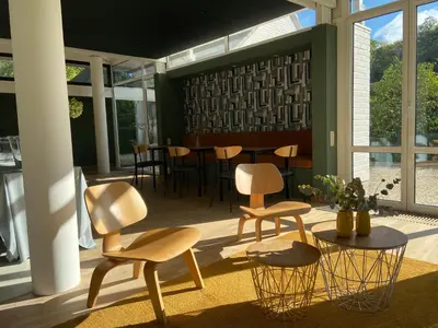 a room with two chairs and a table and windows at The Oak in Wavre