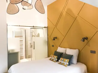 a bedroom with a white bed with a yellow wall at The Oak in Wavre