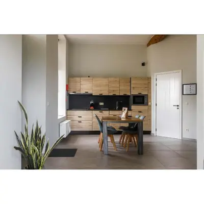a dining room with a table and a kitchen at Lianko - Vakantiewoning in Bekkevoort