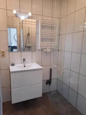 a white bathroom with a sink and a mirror at Central and Cozy in Brussels in Brussels