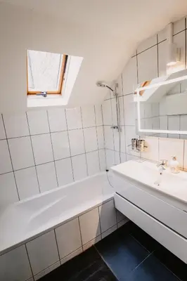 a white bathroom with a sink and a bath tub at Super central in Brussels in Brussels
