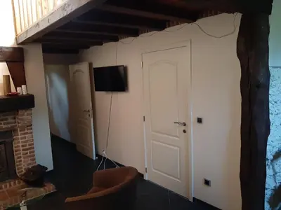 a room with a door and a tv on the wall at Lemen huis Houwaart in Tielt