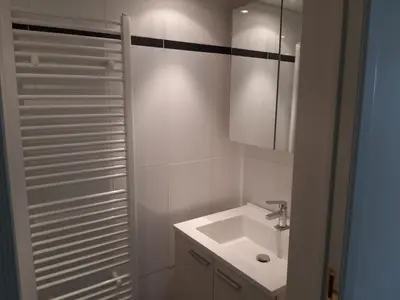 a white bathroom with a sink and a mirror at Lemen huis Houwaart in Tielt