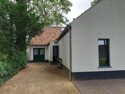 a white house with a door and a window at Lemen huis Houwaart in Tielt
