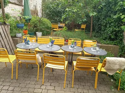 a set of tables and chairs in a garden at Koeketiene Rooms in Ghent