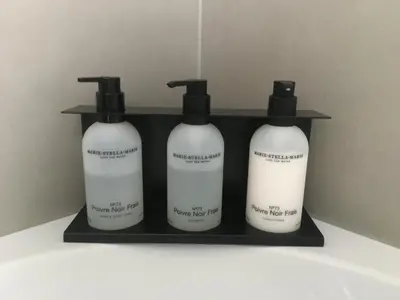 a shelf with three bottles of soap on it at Koeketiene Rooms in Ghent