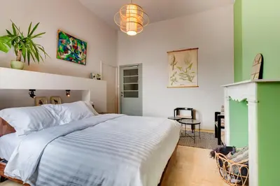a bedroom with a large white bed and a table at Koeketiene Rooms in Ghent