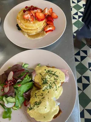 two plates of food with pancakes and a salad at Koeketiene Rooms in Ghent