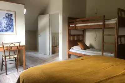 a bedroom with two bunk beds and a desk at De Morgenstond in Baarle-Hertog