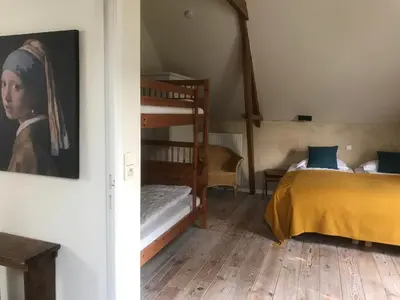 a bedroom with two bunk beds and a painting on the wall at De Morgenstond in Baarle-Hertog