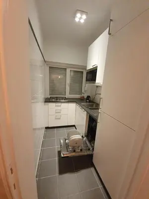 a small kitchen with white cabinets and a white refrigerator at Antwerp Hideaway, outside of low emission zone in Antwerp