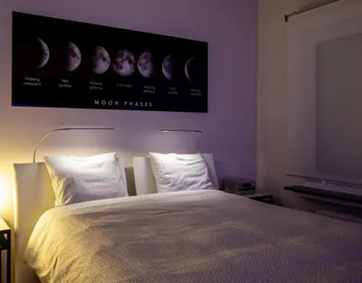 a bedroom with a bed with a poster of moon phases at Antwerp Hideaway, outside of low emission zone in Antwerp