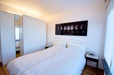 a bedroom with a white bed and a tv on the wall at Antwerp Hideaway, outside of low emission zone in Antwerp