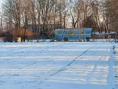 a blue van parked in a snow covered field at Bij grenspaal 243 in Essen