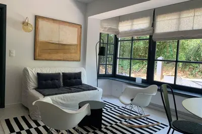 a living room with a couch and chairs and windows at Uccle, Pavillon Vert in Brussels