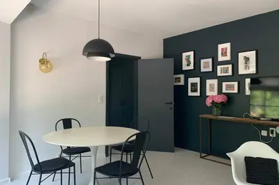 a dining room with a white table and chairs at Uccle, Pavillon Vert in Brussels