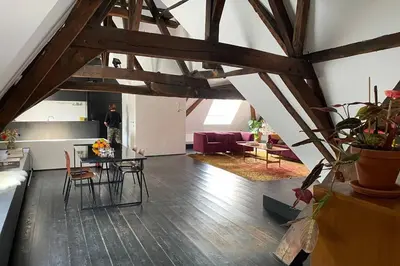 a man standing in a room with a table and chairs at GLORIA LOFT GENT in Ghent