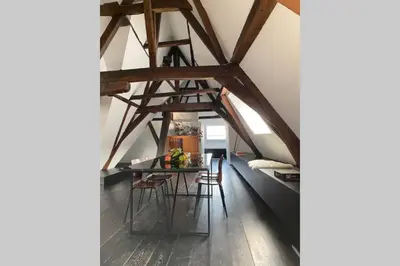 a room with a table and chairs in a attic at GLORIA LOFT GENT in Ghent