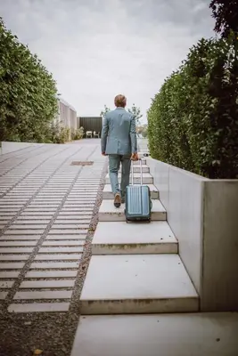 a man walking down some steps with a suitcase at BnB Manere in Grimbergen