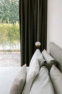 a bed with pillows in front of a window at BnB Manere in Grimbergen