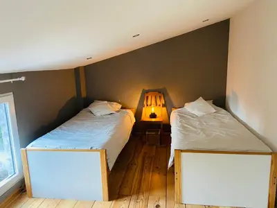 a bedroom with two beds and a lamp at Jolie maison avec jardin. in Hoeilaart