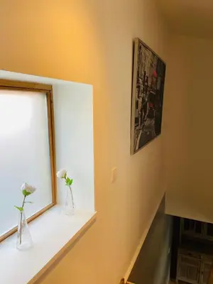 a window with two vases with flowers on a window sill at Jolie maison avec jardin. in Hoeilaart
