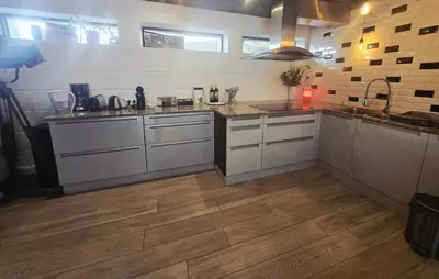 a kitchen with stainless steel appliances and wooden floors at Villa Terlanen in Overijse